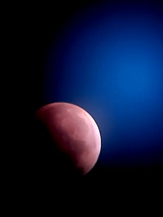 Original photo by me, unretouched. During the end of a lunar eclipse, the moon still had it's red glow at the same time as more light coming through the atmosphere started to excite the blues. (More)'