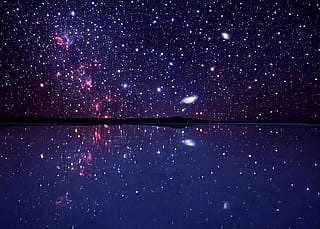 A salt flat reflecting a beautiful sky of stars.'