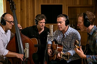 To get ChatGPT to make this image, I had to give it a description of the band and tell it not to tell me the name but just make an image of them in a recording session'